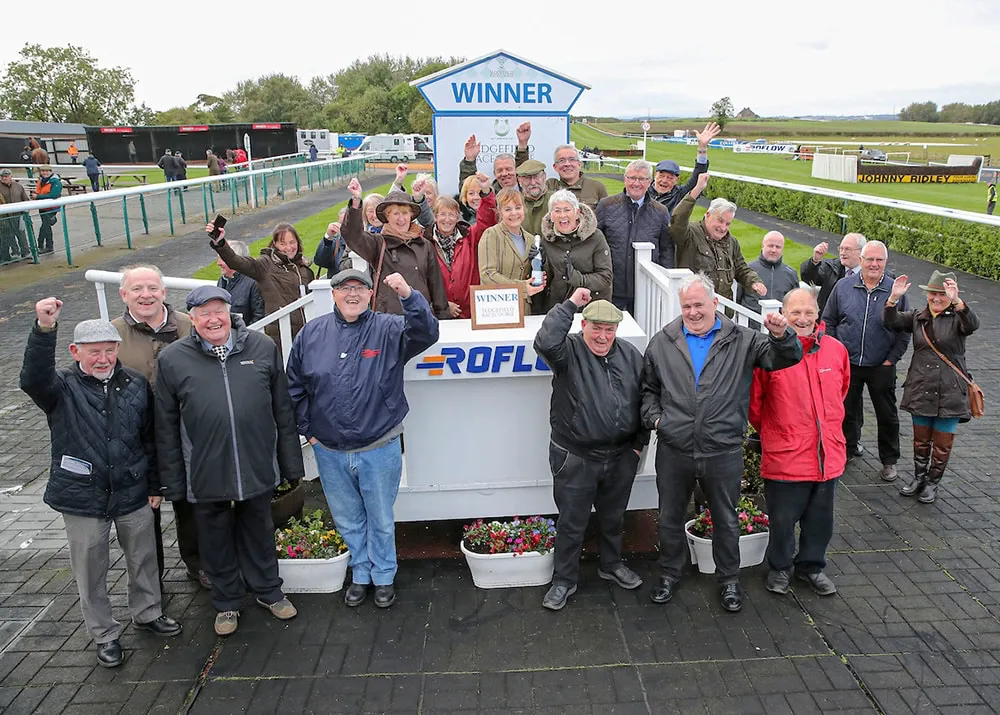 Racehorse owners celebrating with their winner at the racecourse